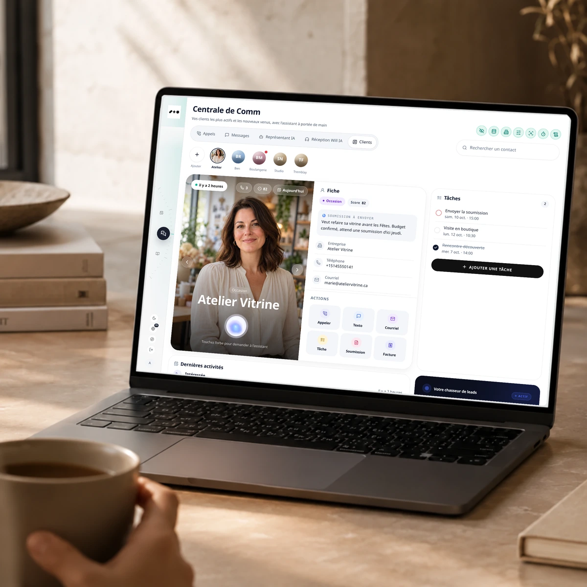 Reach Central AI sur un portable posé sur un bureau de pierre, montrant une fiche client avec une photo de profil, les coordonnées, les actions et les tâches de suivi.